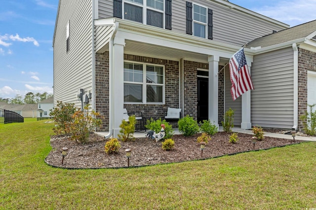 7037 Grant St, Little River, SC 29566 - view of front of house featuring brick siding, a front yard, covered porch, and a garage
