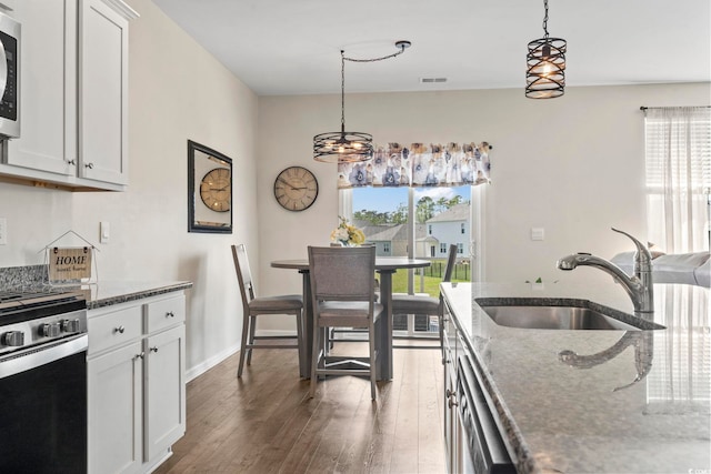 7037 Grant St, Little River, SC 29566 - kitchen with a sink, stainless steel appliances, plenty of natural light, and dark stone counters