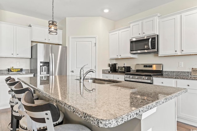 7037 Grant St, Little River, SC 29566 - kitchen with appliances with stainless steel finishes, a sink, recessed lighting, white cabinetry, and a kitchen breakfast bar