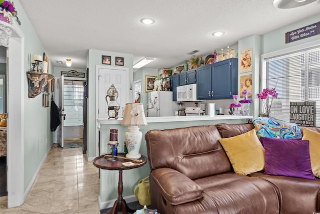 213 Landing Rd Unit A, North Myrtle Beach, SC 29582 - kitchen featuring white appliances, blue cabinets, light marble finish floors, a textured ceiling, and healthy amount of natural light