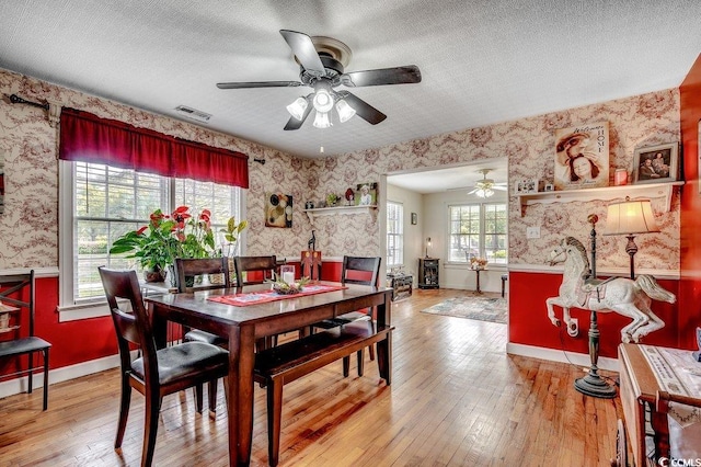 dining room featuring visible vents, wallpapered walls, and a ceiling fan