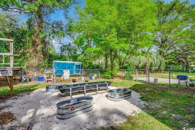 view of patio with a garden, fence, and a gate