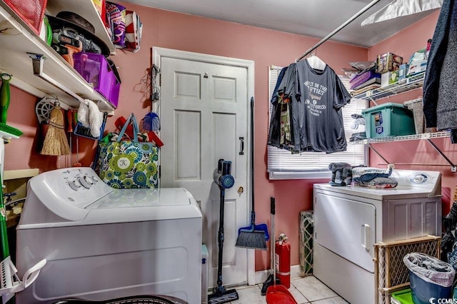 clothes washing area featuring tile patterned floors, washing machine and dryer, and laundry area