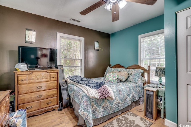 bedroom featuring visible vents, light wood-style flooring, and a ceiling fan