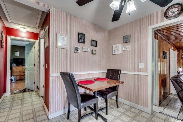 dining space with baseboards, a ceiling fan, attic access, wallpapered walls, and light floors