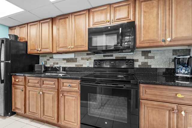1501 S Ocean Blvd Unit 845, Myrtle Beach, SC 29577 - kitchen featuring tasteful backsplash, dark stone countertops, light tile patterned floors, black appliances, and a sink