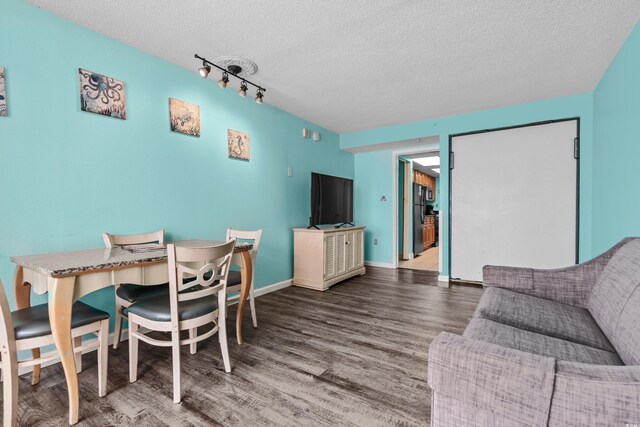 1501 S Ocean Blvd Unit 845, Myrtle Beach, SC 29577 - dining area featuring baseboards, rail lighting, wood finished floors, and a textured ceiling