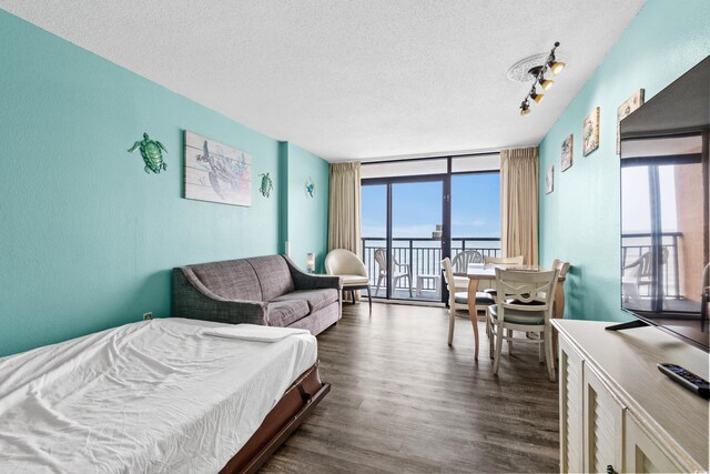 1501 S Ocean Blvd Unit 845, Myrtle Beach, SC 29577 - bedroom featuring dark wood-style flooring, a wall of windows, and a textured ceiling