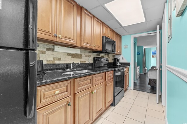 1501 S Ocean Blvd Unit 845, Myrtle Beach, SC 29577 - kitchen featuring light tile patterned floors, black appliances, dark stone counters, decorative backsplash, and a sink