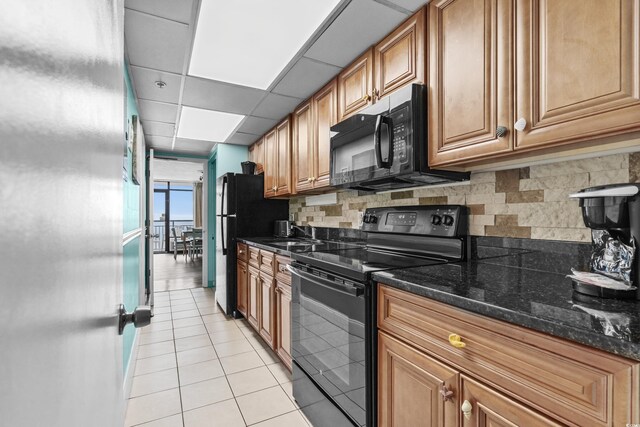 1501 S Ocean Blvd Unit 845, Myrtle Beach, SC 29577 - kitchen featuring light tile patterned floors, a paneled ceiling, brown cabinets, black appliances, and backsplash