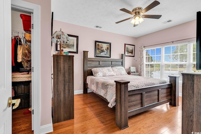 5090 Windsor Green Way Unit 103, Myrtle Beach, SC 29579 - bedroom featuring light wood-type flooring, a textured ceiling, and a ceiling fan