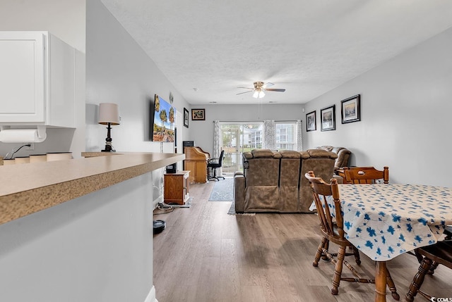 5090 Windsor Green Way Unit 103, Myrtle Beach, SC 29579 - dining space with light wood-type flooring, a ceiling fan, and a textured ceiling