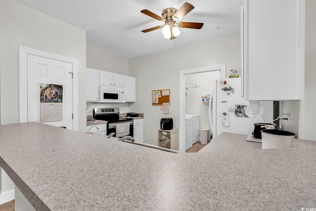 5090 Windsor Green Way Unit 103, Myrtle Beach, SC 29579 - kitchen with white appliances, washer and clothes dryer, ceiling fan, white cabinetry, and a peninsula