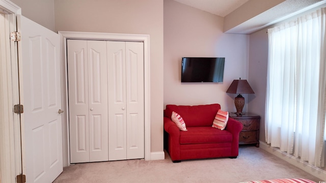 sitting room featuring carpet flooring and baseboards