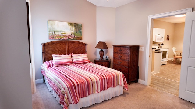 bedroom with light colored carpet and baseboards