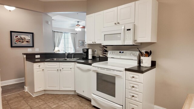 kitchen with a sink, ceiling fan, white cabinetry, and white appliances