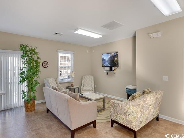 living area with visible vents and baseboards