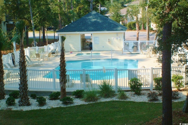 community pool with a patio and fence