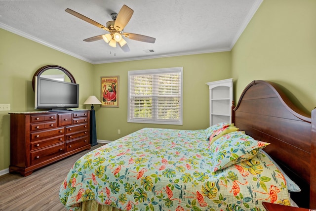 bedroom featuring a textured ceiling, baseboards, crown molding, and wood finished floors