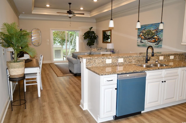 kitchen with dishwashing machine, a sink, a tray ceiling, light wood finished floors, and ornamental molding