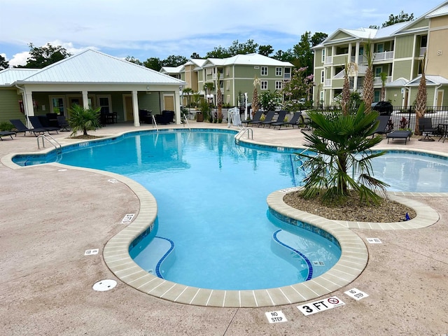 community pool with fence and a patio