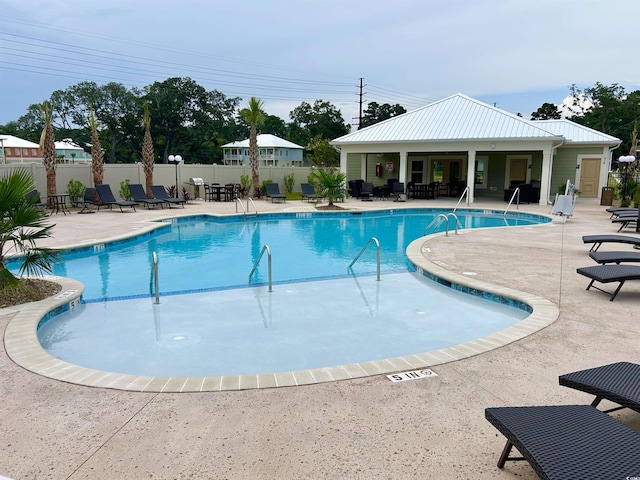 community pool with fence and a patio