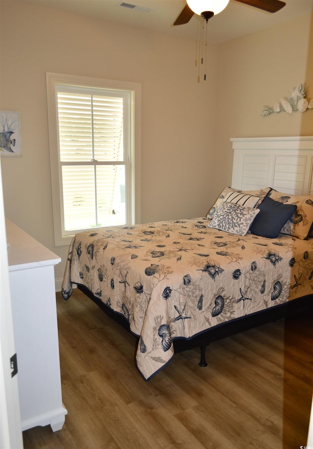 bedroom featuring wood finished floors, a ceiling fan, and baseboards