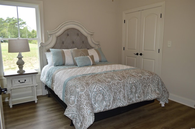 bedroom with a closet, wood finished floors, and baseboards