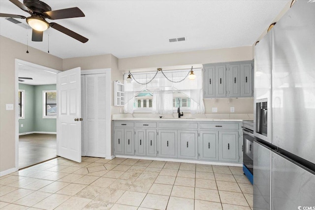 2108 Brunswick Cir, Little River, SC 29566 - kitchen with appliances with stainless steel finishes, light countertops, a ceiling fan, gray cabinets, and light tile patterned floors