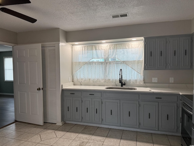 2108 Brunswick Cir, Little River, SC 29566 - kitchen with a ceiling fan, range with electric cooktop, gray cabinetry, light countertops, and a textured ceiling