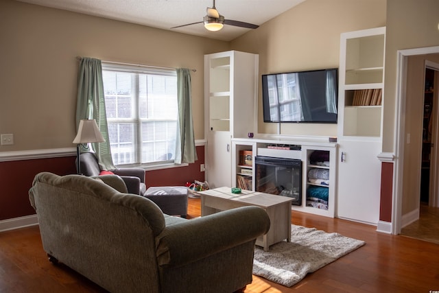 7473 Louisville Rd, Aynor, SC 29511 - living area with wood finished floors, baseboards, a ceiling fan, and a glass covered fireplace