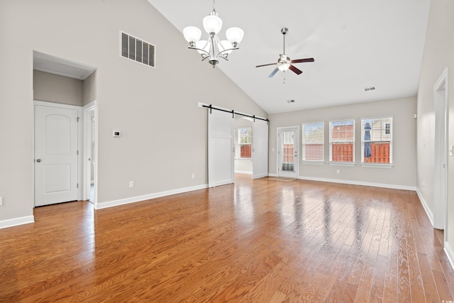 826 Sand Binder Dr, Myrtle Beach, SC 29579 - spare room with high vaulted ceiling, a barn door, a ceiling fan, light wood-type flooring, and a chandelier
