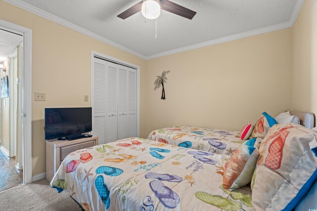 9600 Shore Dr Unit A-207, Myrtle Beach, SC 29572 - carpeted bedroom featuring ornamental molding, a closet, a ceiling fan, baseboards, and a textured ceiling