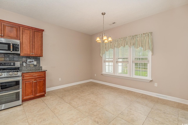 406 Pritchard St, Myrtle Beach, SC 29588 - kitchen with backsplash, baseboards, dark stone countertops, an inviting chandelier, and stainless steel appliances
