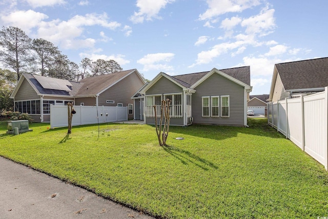 406 Pritchard St, Myrtle Beach, SC 29588 - rear view of property featuring a sunroom, a lawn, fence, and solar panels