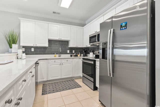 4861 Luster Leaf Cir Unit 104, Myrtle Beach, SC 29577 - kitchen with appliances with stainless steel finishes, ornamental molding, white cabinets, decorative backsplash, and light tile patterned floors