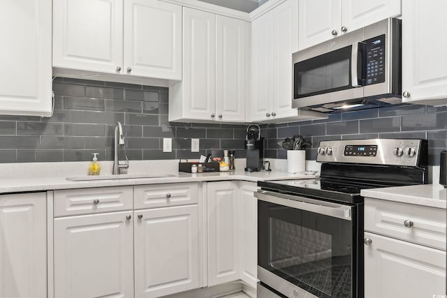 4861 Luster Leaf Cir Unit 104, Myrtle Beach, SC 29577 - kitchen with stainless steel appliances, a sink, white cabinets, and decorative backsplash