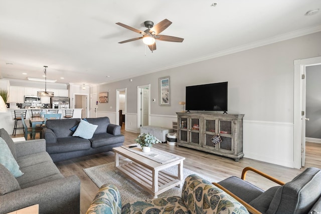 4861 Luster Leaf Cir Unit 104, Myrtle Beach, SC 29577 - living area with ceiling fan, crown molding, light wood-style floors, and a wainscoted wall