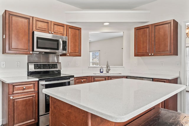 601 Seth Ln, Longs, SC 29568 - kitchen with appliances with stainless steel finishes, a sink, a center island, light stone counters, and brown cabinets