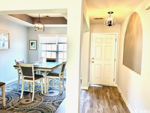 232 Marbella Dr, Murrells Inlet, SC 29576 - dining room featuring a chandelier, wood finished floors, baseboards, and arched walkways