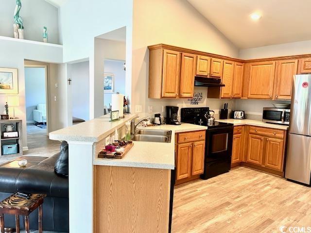 232 Marbella Dr, Murrells Inlet, SC 29576 - kitchen featuring appliances with stainless steel finishes, under cabinet range hood, a sink, high vaulted ceiling, and a peninsula