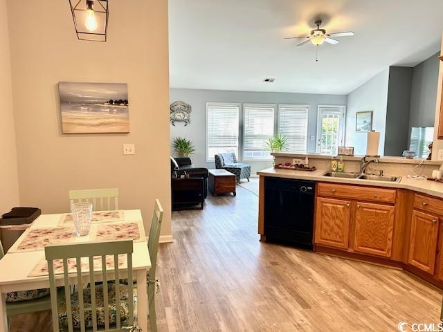 232 Marbella Dr, Murrells Inlet, SC 29576 - kitchen with black dishwasher, a sink, light wood-style floors, ceiling fan, and brown cabinetry