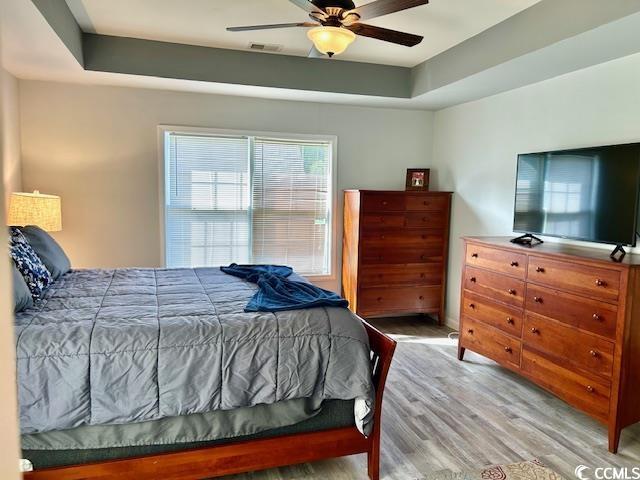 232 Marbella Dr, Murrells Inlet, SC 29576 - bedroom with light wood finished floors, multiple windows, and a ceiling fan