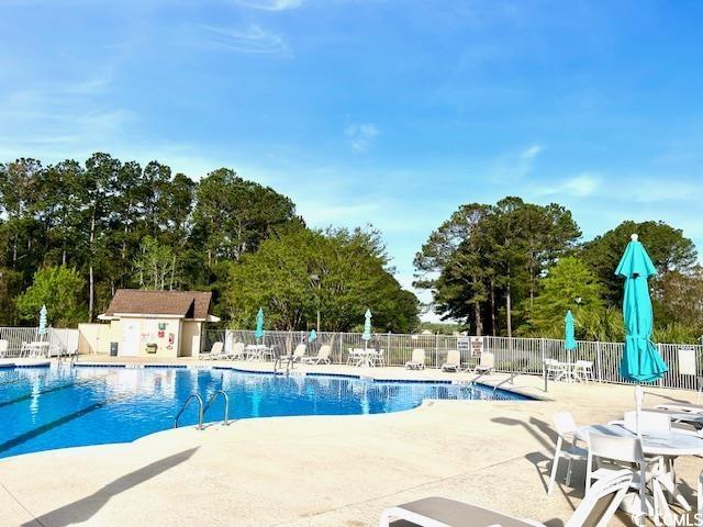 232 Marbella Dr, Murrells Inlet, SC 29576 - community pool featuring fence, a patio area, and view of scattered trees