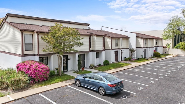 view of front of house featuring uncovered parking and fence