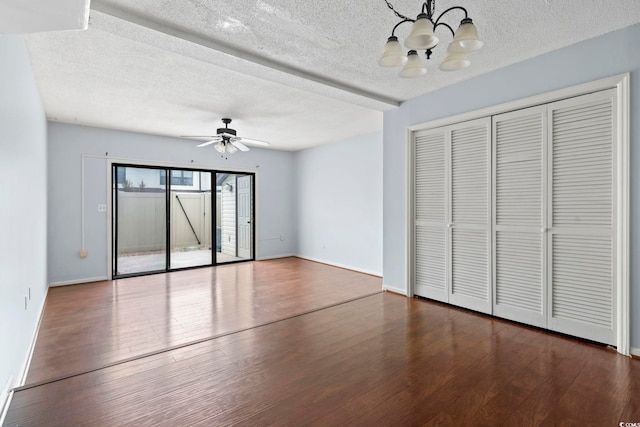 interior space featuring ceiling fan with notable chandelier, a textured ceiling, baseboards, and dark wood finished floors