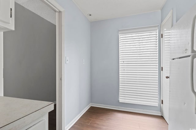 unfurnished dining area with baseboards and wood finished floors