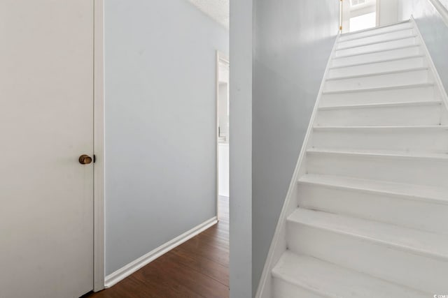 stairs with wood finished floors and baseboards