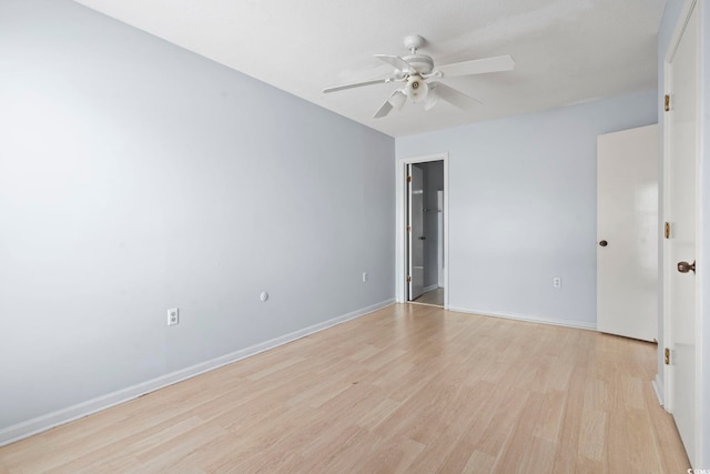 empty room featuring baseboards, a ceiling fan, and light wood finished floors