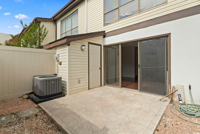 view of patio with fence and cooling unit